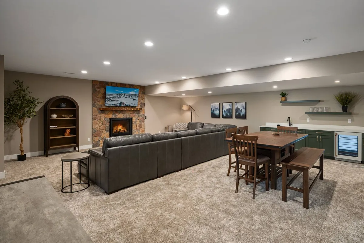 A cozy lounge area with a fireplace, ample sofa seating, a dining area, and a large television. The arrangement invites movie nights, game sessions, and group gatherings, creating a welcoming ambiance for relaxation and connection.