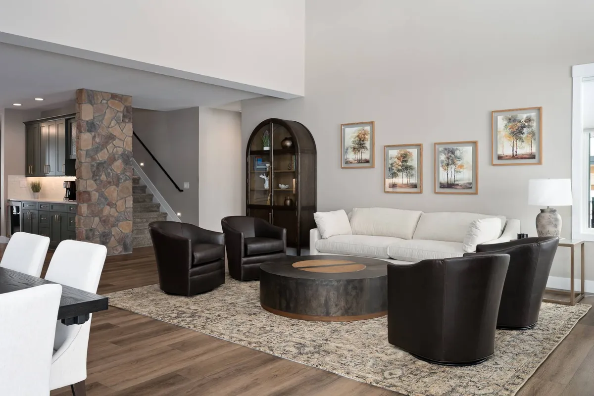 A cozy living room with a plush sofa, central coffee table, dramatic stone feature wall, and artwork. The space invites both relaxation and casual conversation, supporting a range of group activities from game nights to quiet reading.